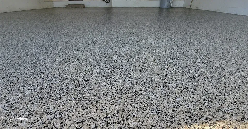 Close-up of a speckled, gray epoxy floor. Shiny, smooth surface.
