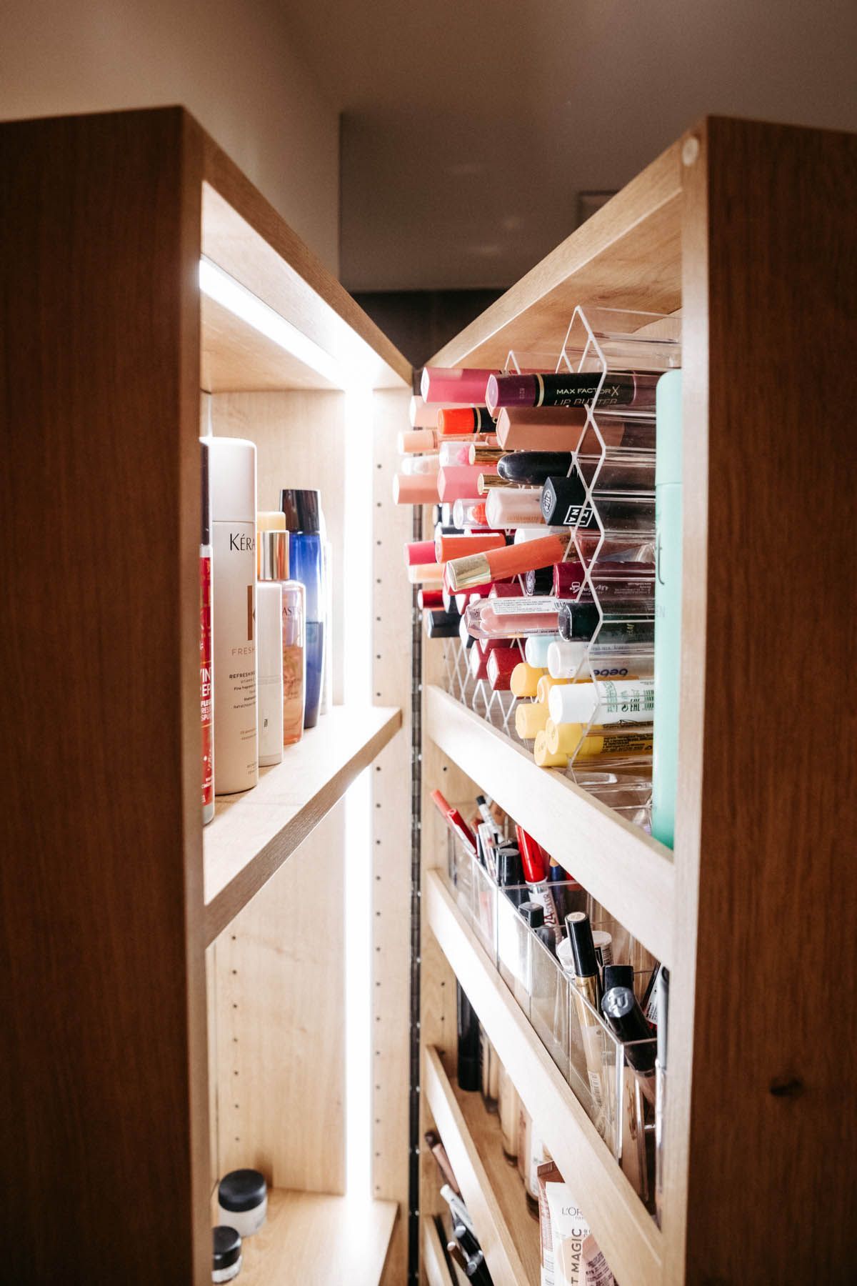 Kosmetikschrank aus Holz mit Regalen voller Make-up.