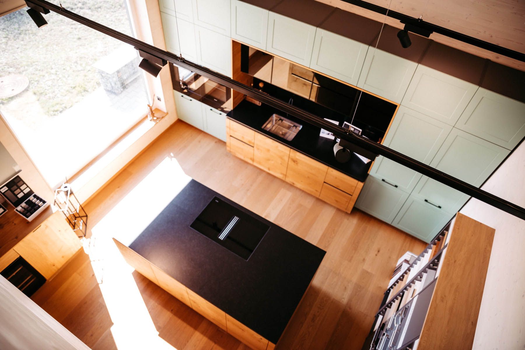 Moderne Küche mit großer Kochinsel und hellen Holzschränken, Draufsicht.