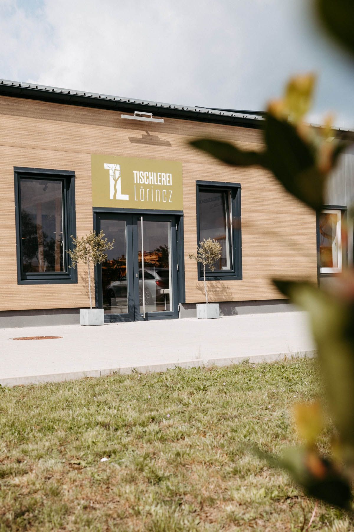 Ein Gebäude mit einer Holzfassade und einem Schild mit der Aufschrift „TL Studio“.