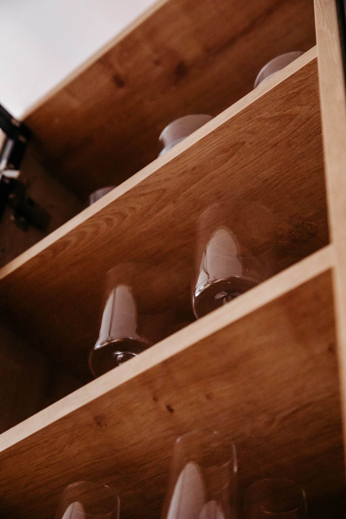 Holzschrank mit Regalen für verschiedene Stielgläser.