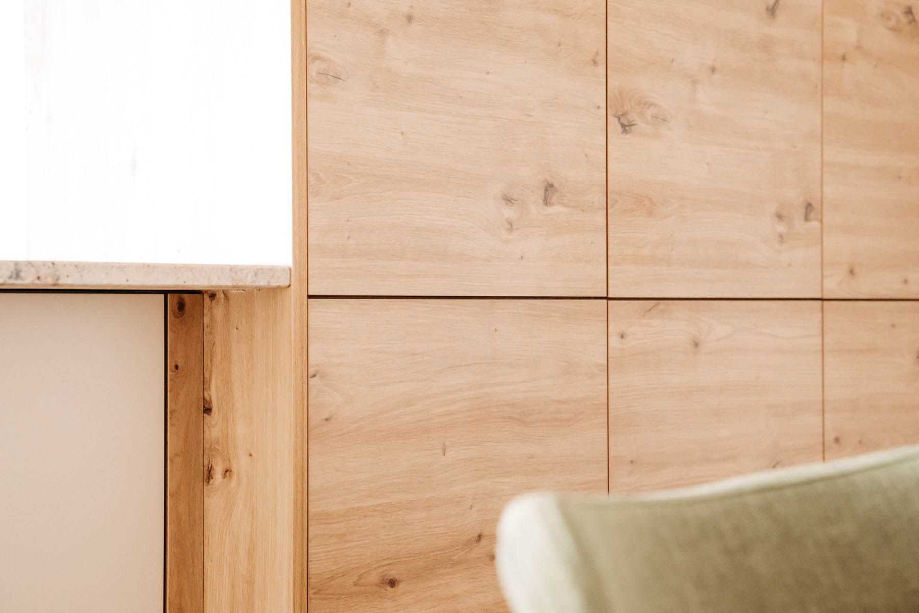 Holzschränke mit Arbeitsplatte und einem Teil eines Stuhls.