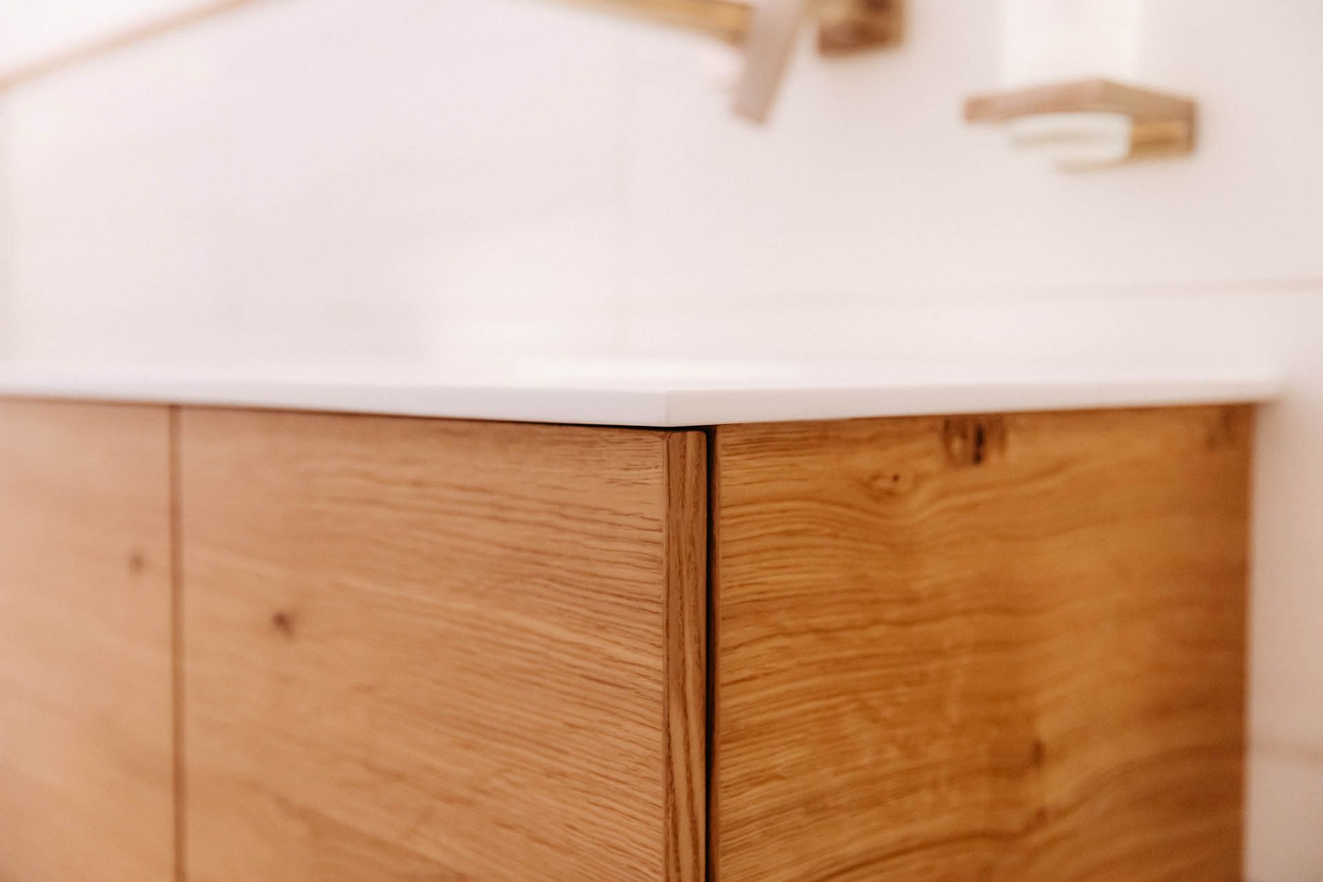 Badezimmerschrank aus Holz mit weißer Arbeitsplatte.