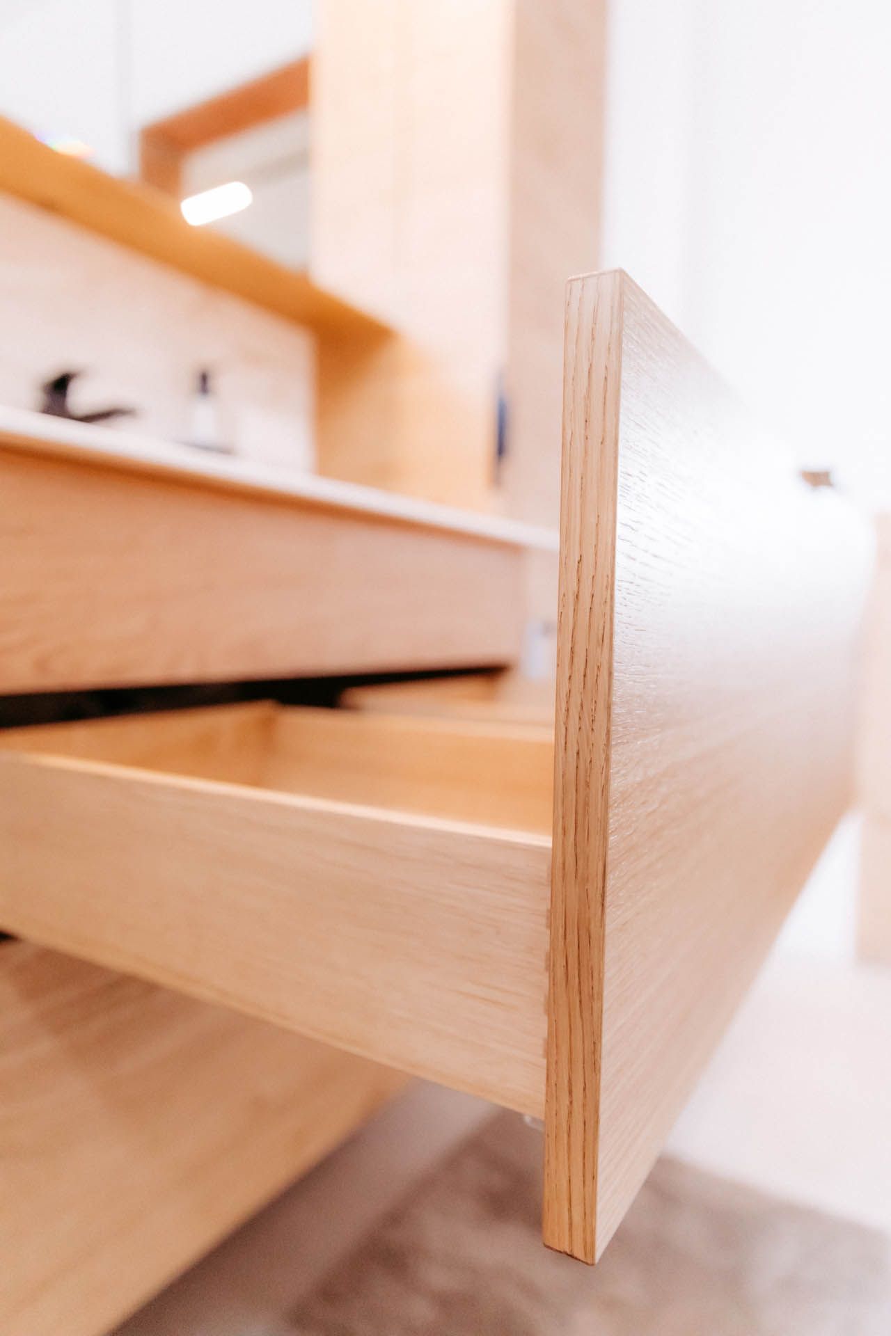 Offene Badezimmerschublade aus Holz in hellem, modernem Ambiente.