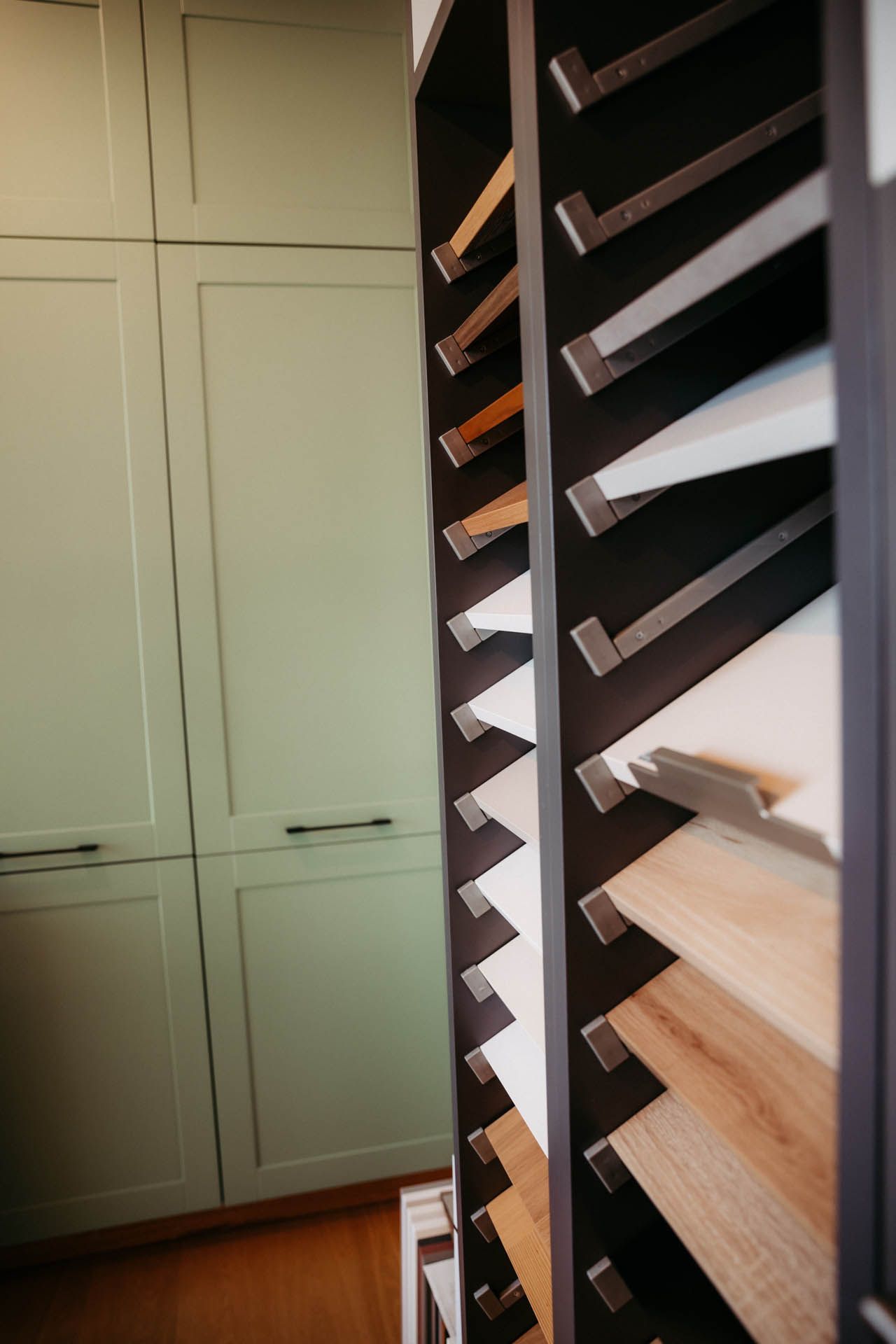 Ausstellung von Schranktürmustern in einem Ausstellungsraum, mit grünen Schränken im Hintergrund.