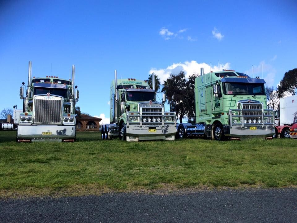 Three Green Semi Trucks Parked on Grass — Dawson's Removals In Kelso, NSW