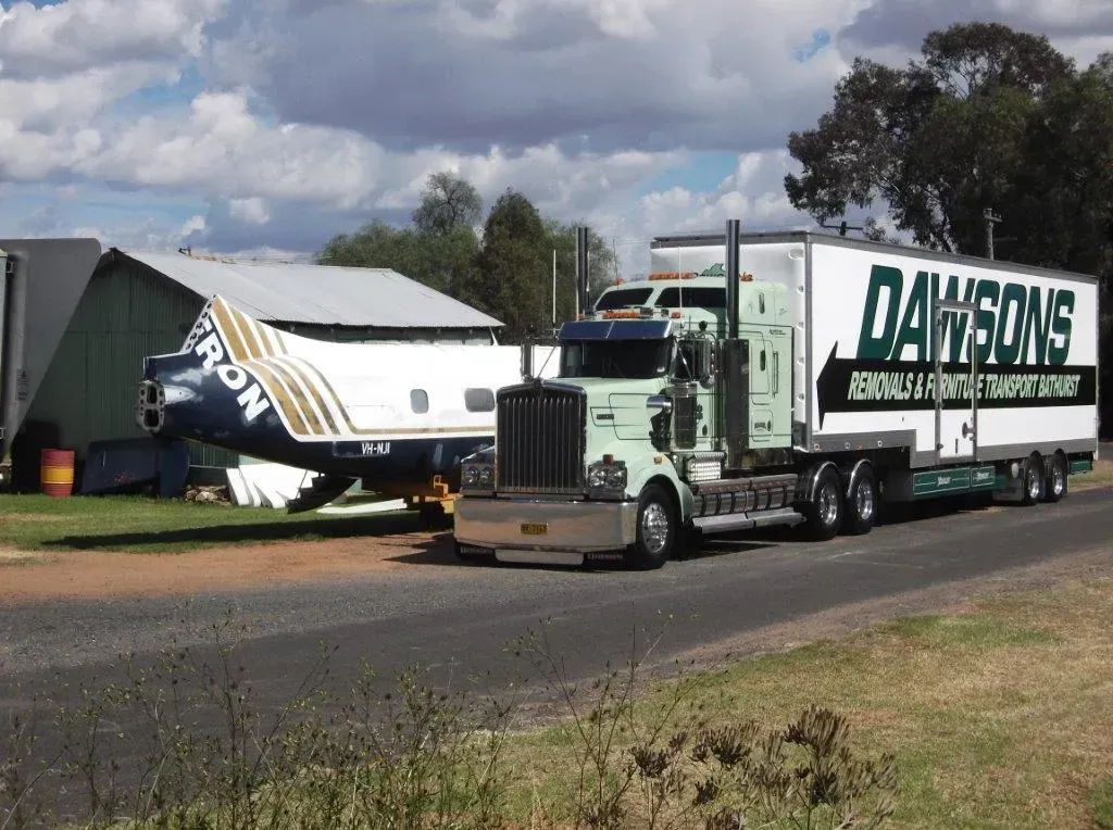 Two White SemiTrucks with Dawsons Logos Parked on A Rural Roadside — Dawson's Removals In Kelso, NSW