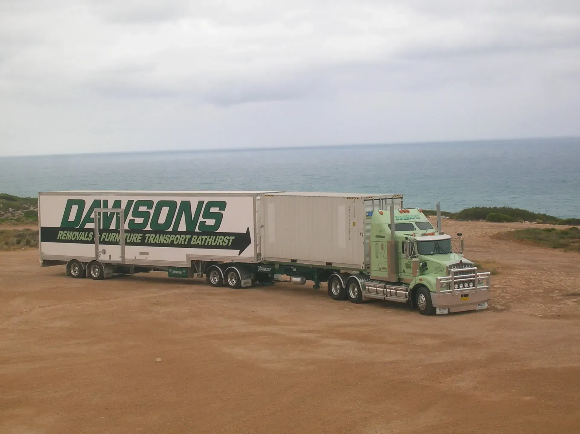 Green Dawson Semi Truck Parked on A Dirt Overlook Above the Ocean — Dawson's Removals In Kelso, NSW