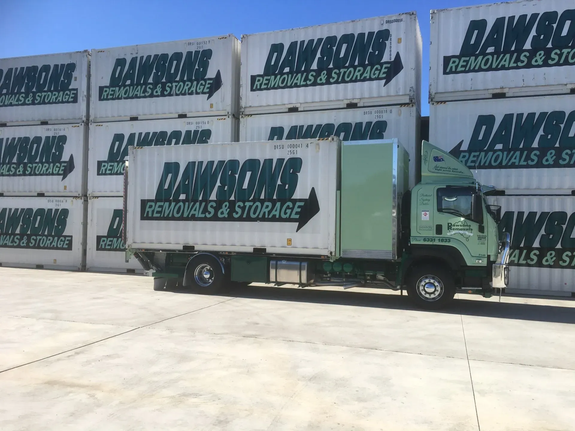 Green Dawson Truck Parked in Front of Stacked Dawsons Removals & Storage Containers — Dawson's Removals In Kelso, NSW