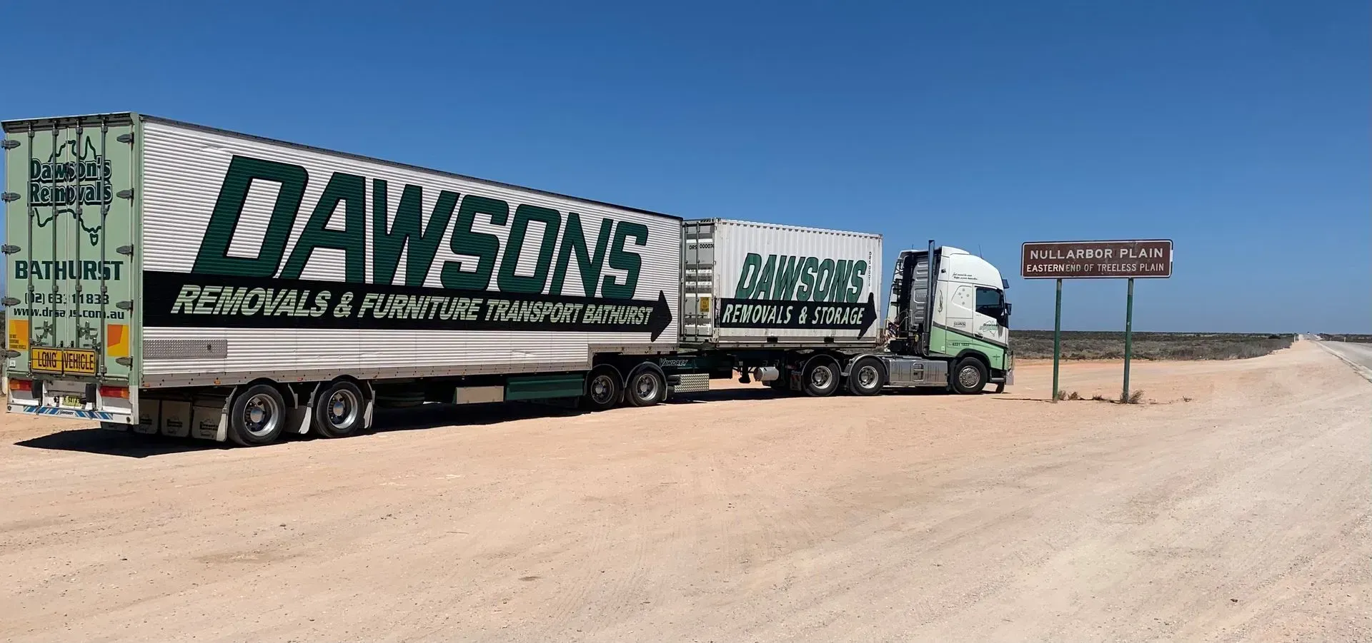 A White Dawsons Semi Truck Parked on A Dirt Road in A Desert Landscape — Dawson's Removals In Kelso, NSW