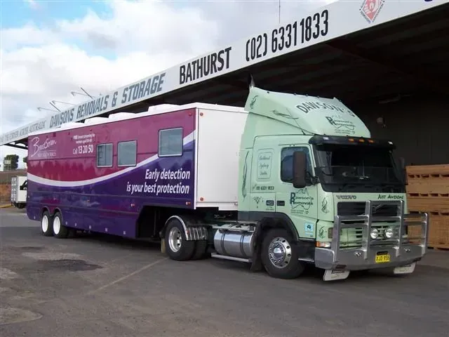 Large Truck With a Pink and Purple Trailer, Labeled — Dawson's Removals In Kelso, NSW