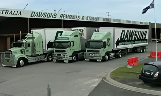 Three Green Dawsons Removals Trucks Parked Beside a Warehouse — Dawson's Removals In Kelso, NSW