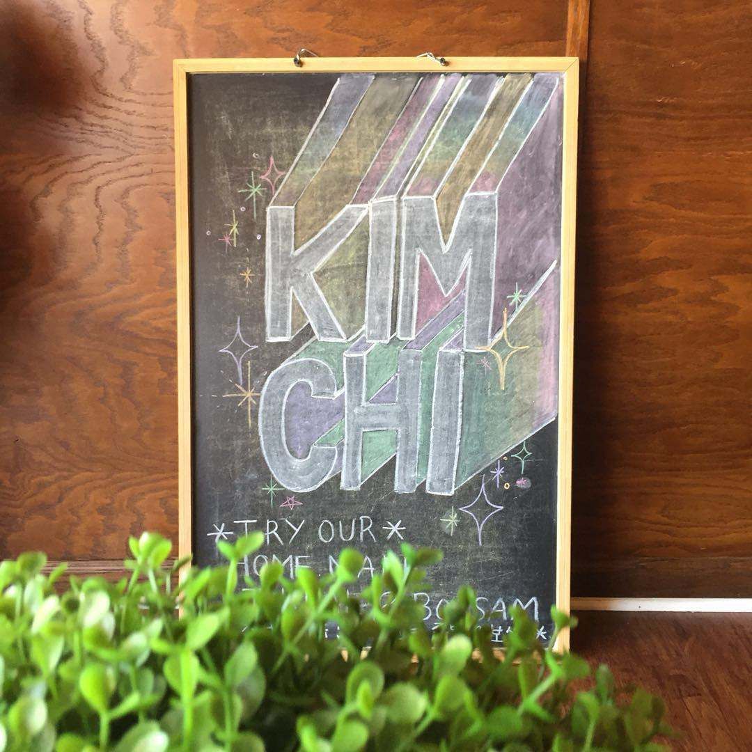 A blackboard with the name kim chi written on it