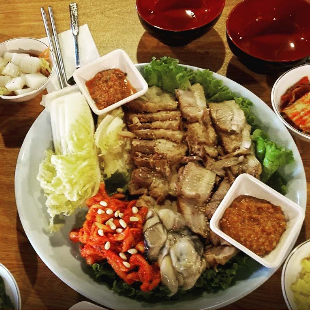 A plate of food with sauces and vegetables on a table