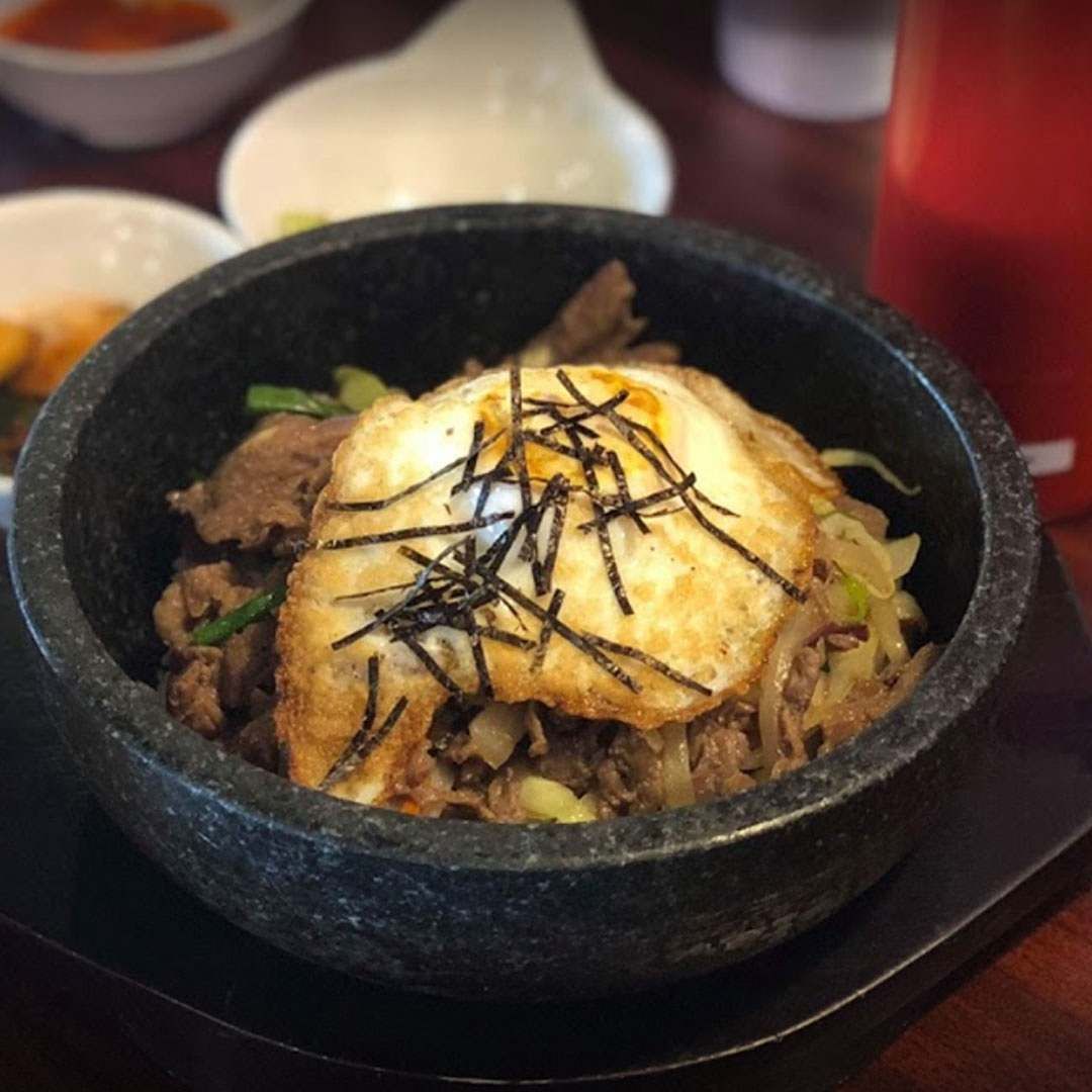 A bowl of food with a fried egg on top