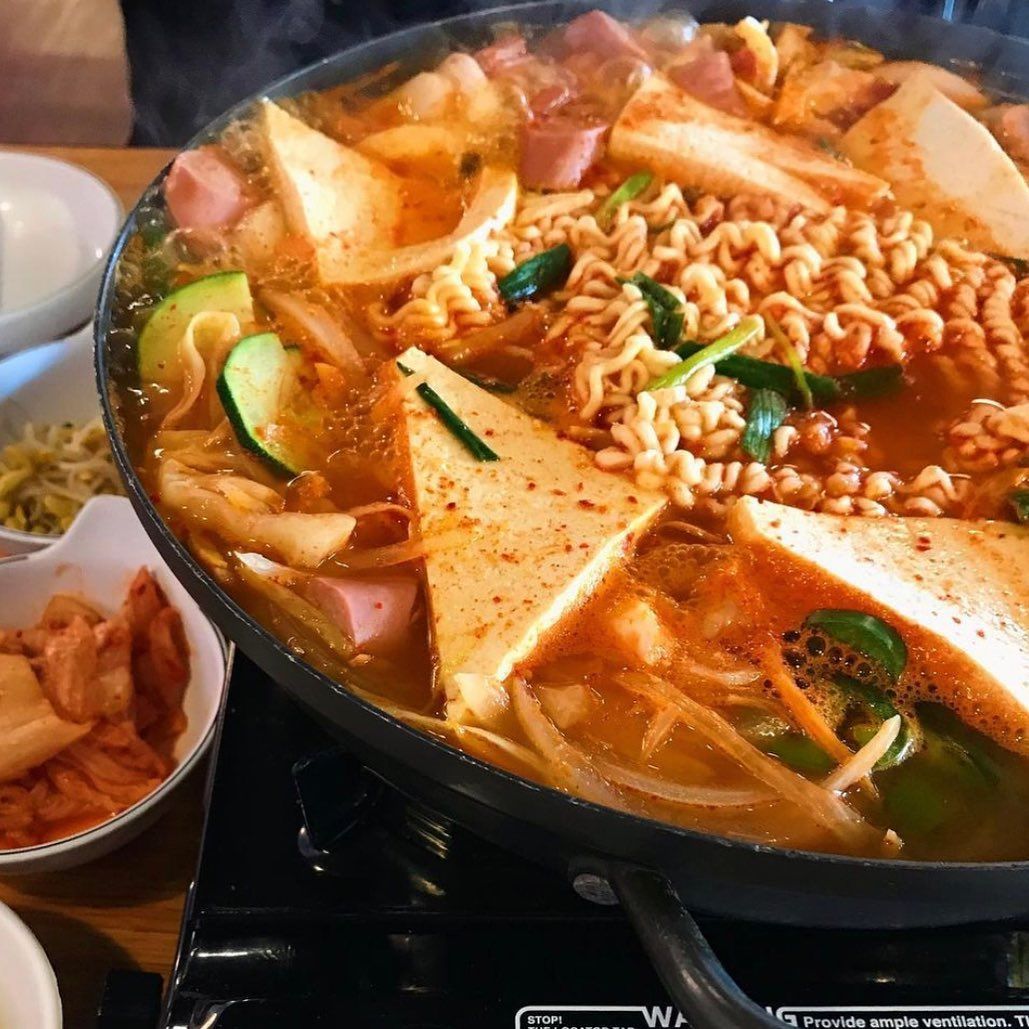 A pan filled with noodles and vegetables on a stove top