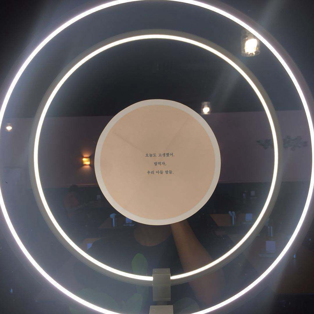 A lighted circle with a reflection of a person in it
