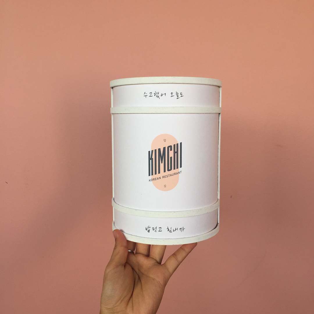 A person is holding a can that says kimchi on it