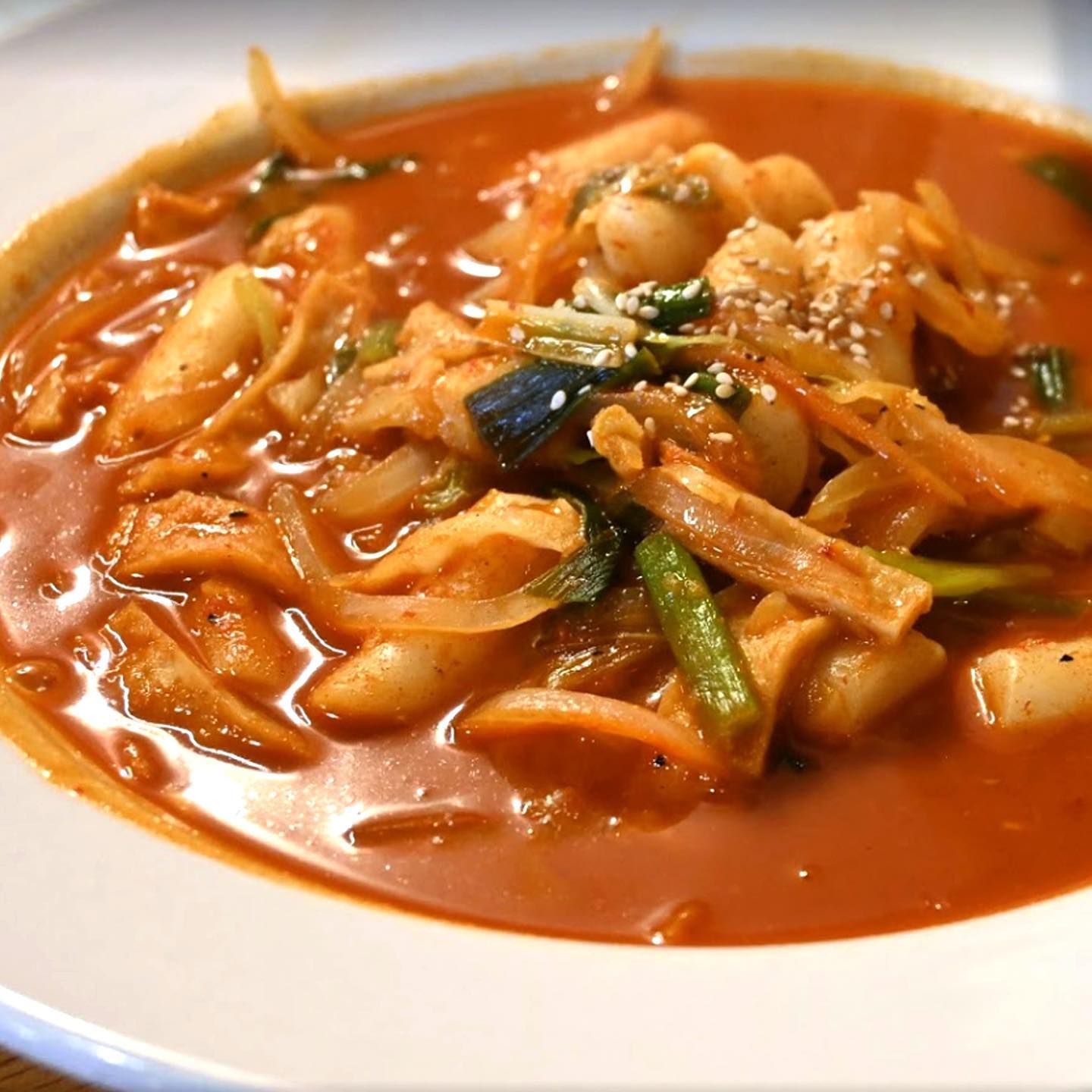 A close up of a bowl of soup with meat and vegetables