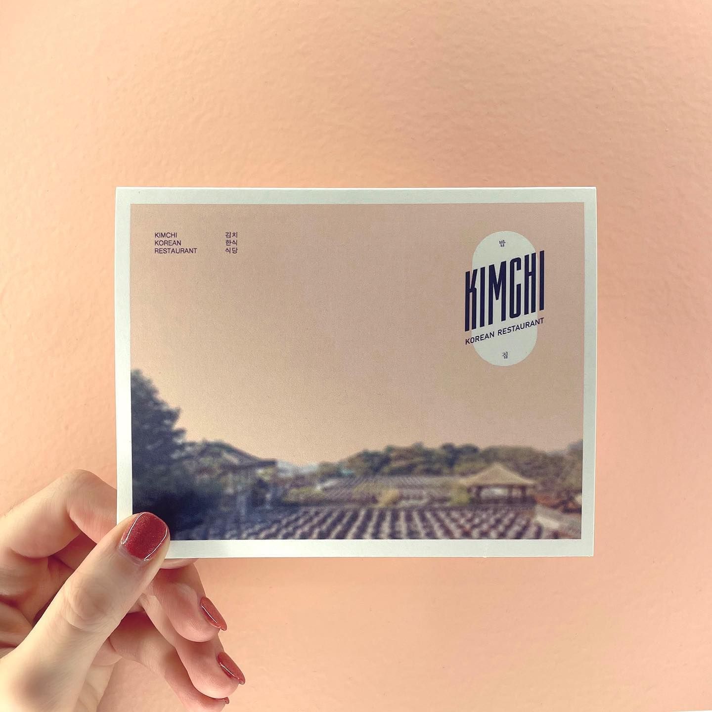 A person is holding a card that says kimchi on it