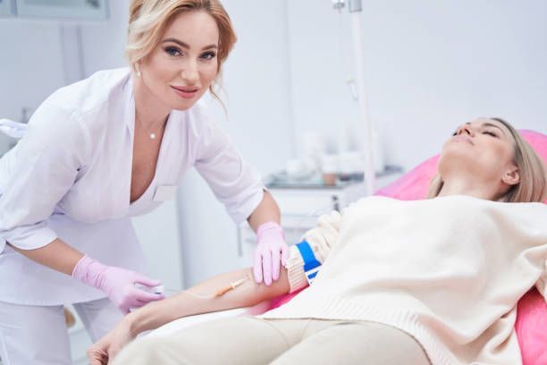 A nurse is giving a patient an injection in her arm.
