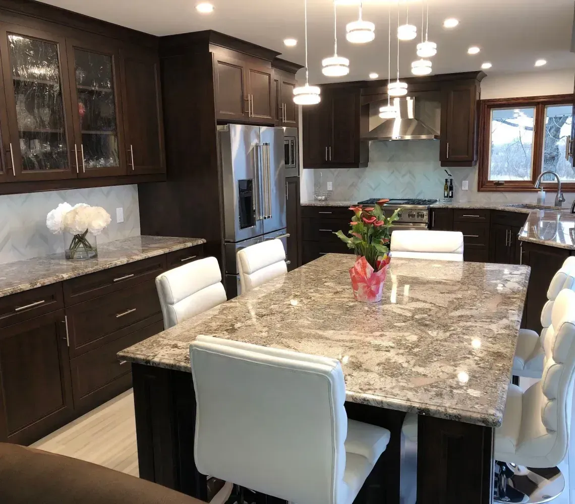 A kitchen featuring dark wood cabinets, granite countertops, a large center island with white chairs, and pendant lights.