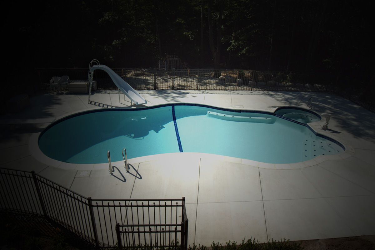 Swimming Pool With Water Slide And Fence — Warren, MI  — Sardelli Custom Pools