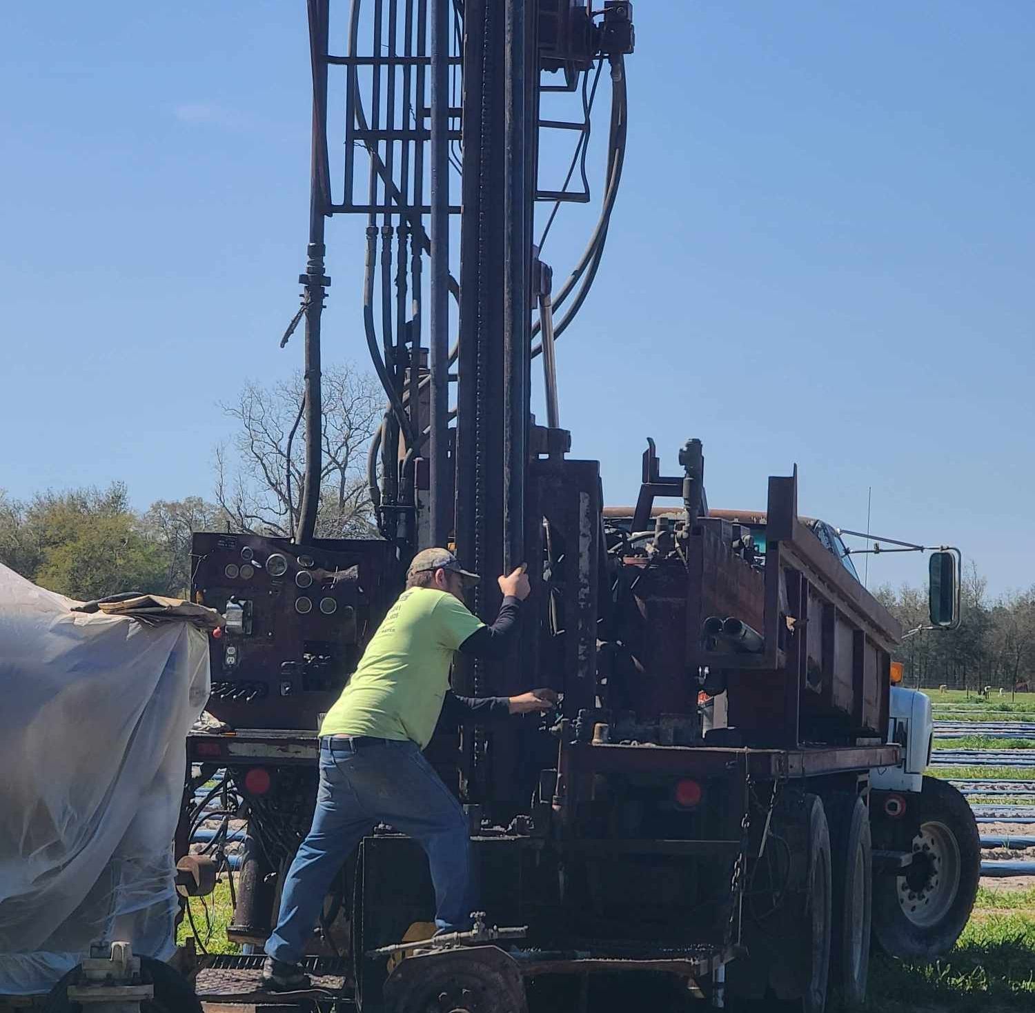 A person is using a drill to dig a hole in the ground.