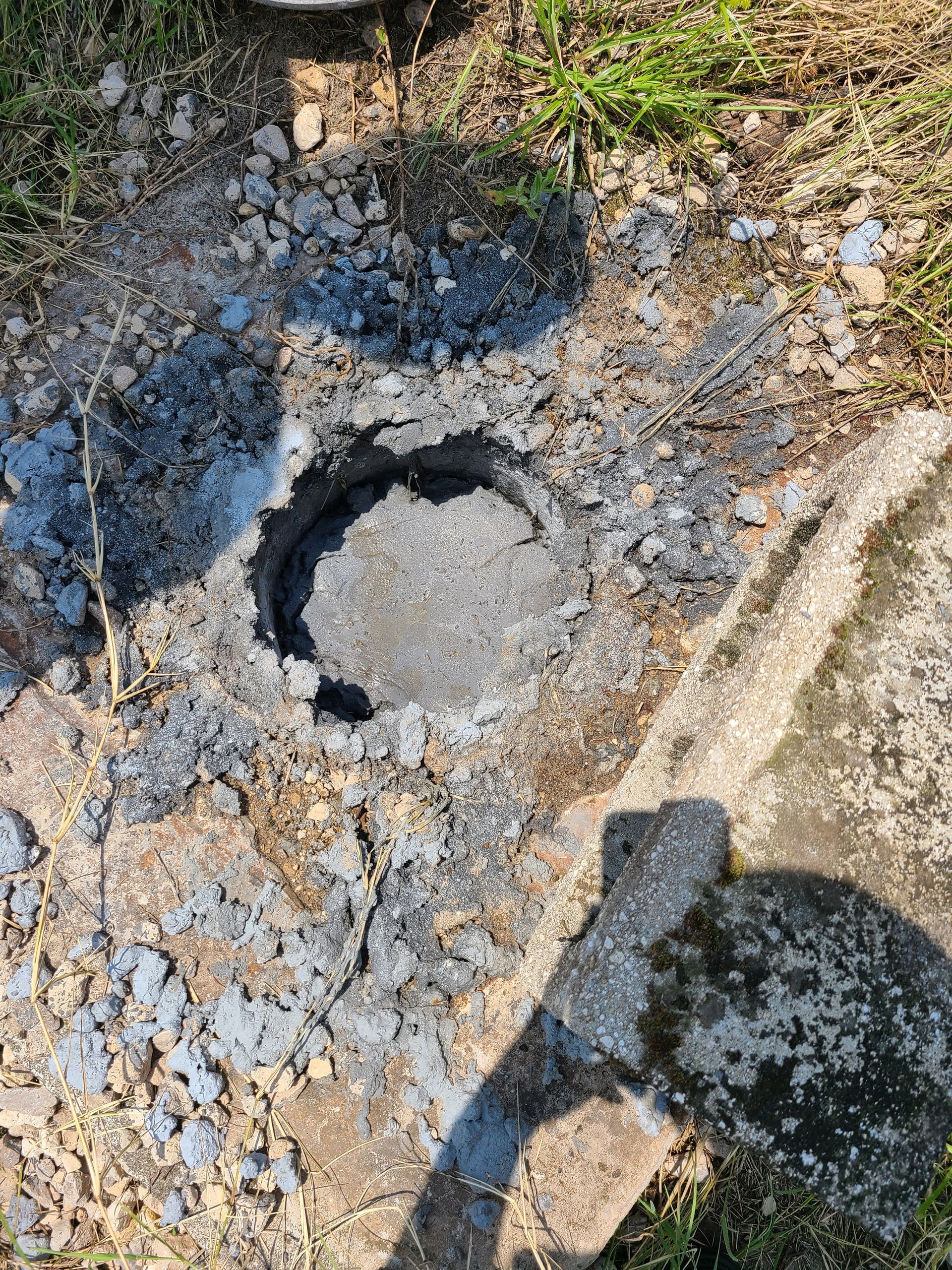 A blue pipe is sitting in the middle of a grassy field.