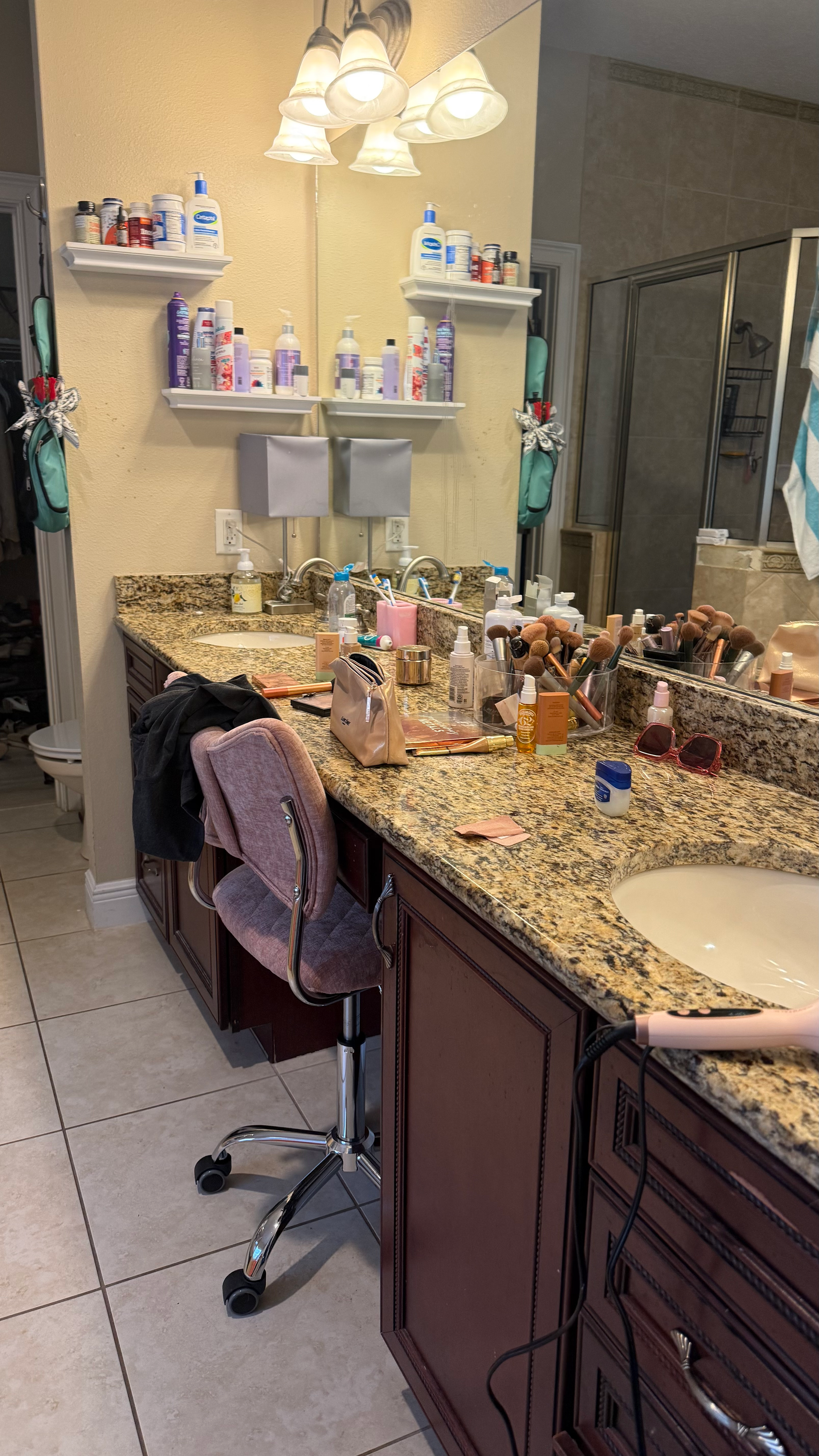 A bathroom with two sinks , a chair and a mirror.