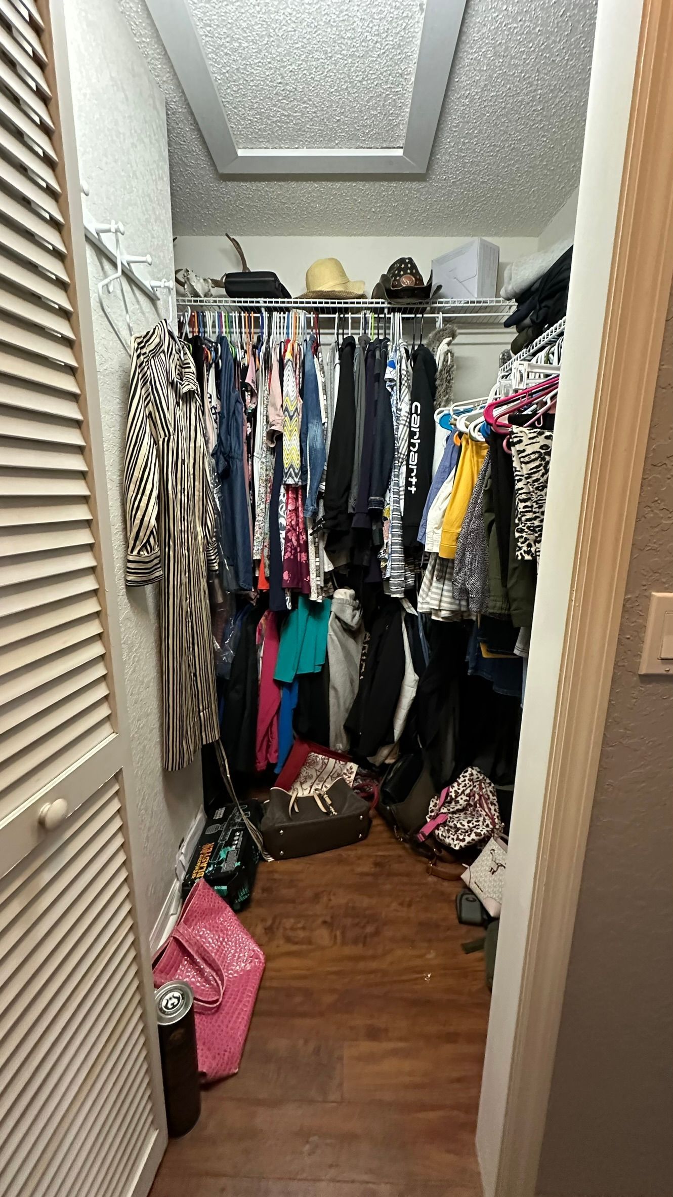 A walk in closet filled with lots of clothes and shoes.
