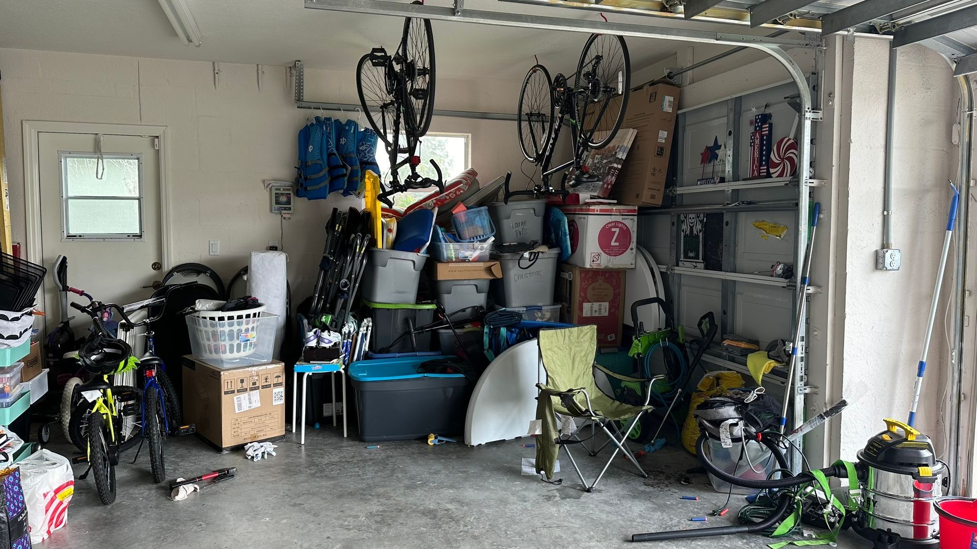 A garage filled with lots of boxes and bicycles.