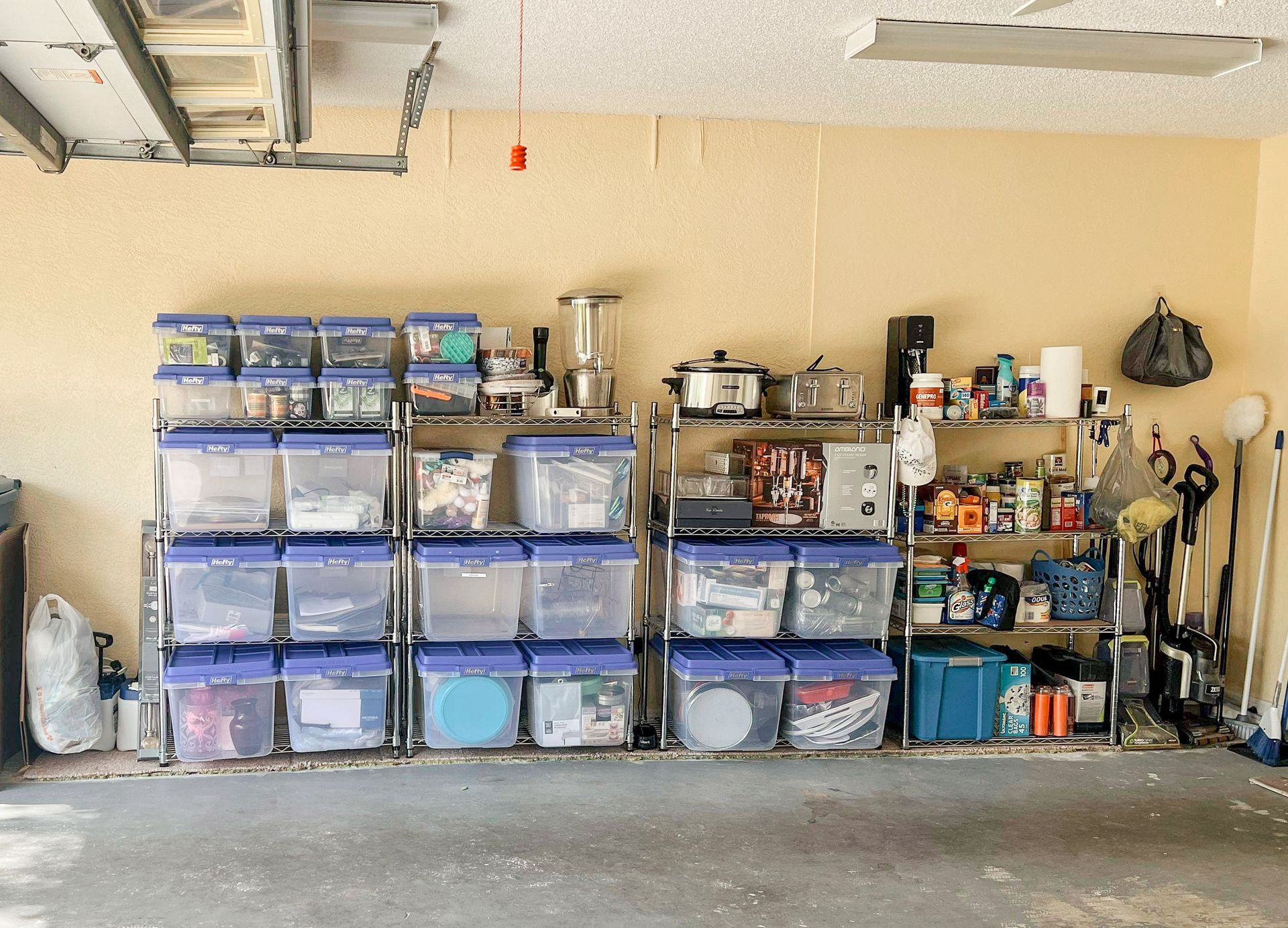 A garage filled with lots of plastic bins and shelves.