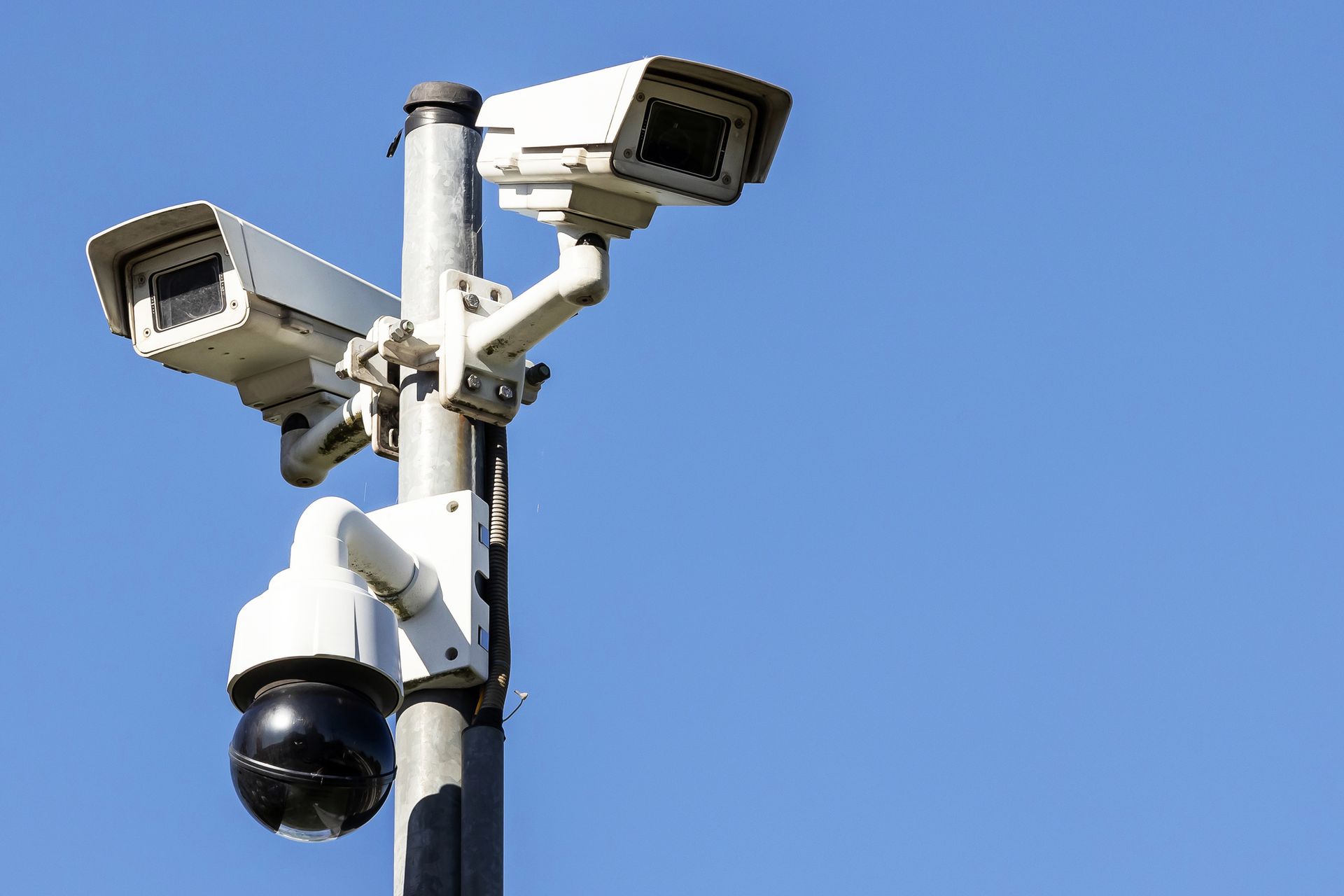 Many surveillance cameras against blue sky Many surveillance cameras against blue sky