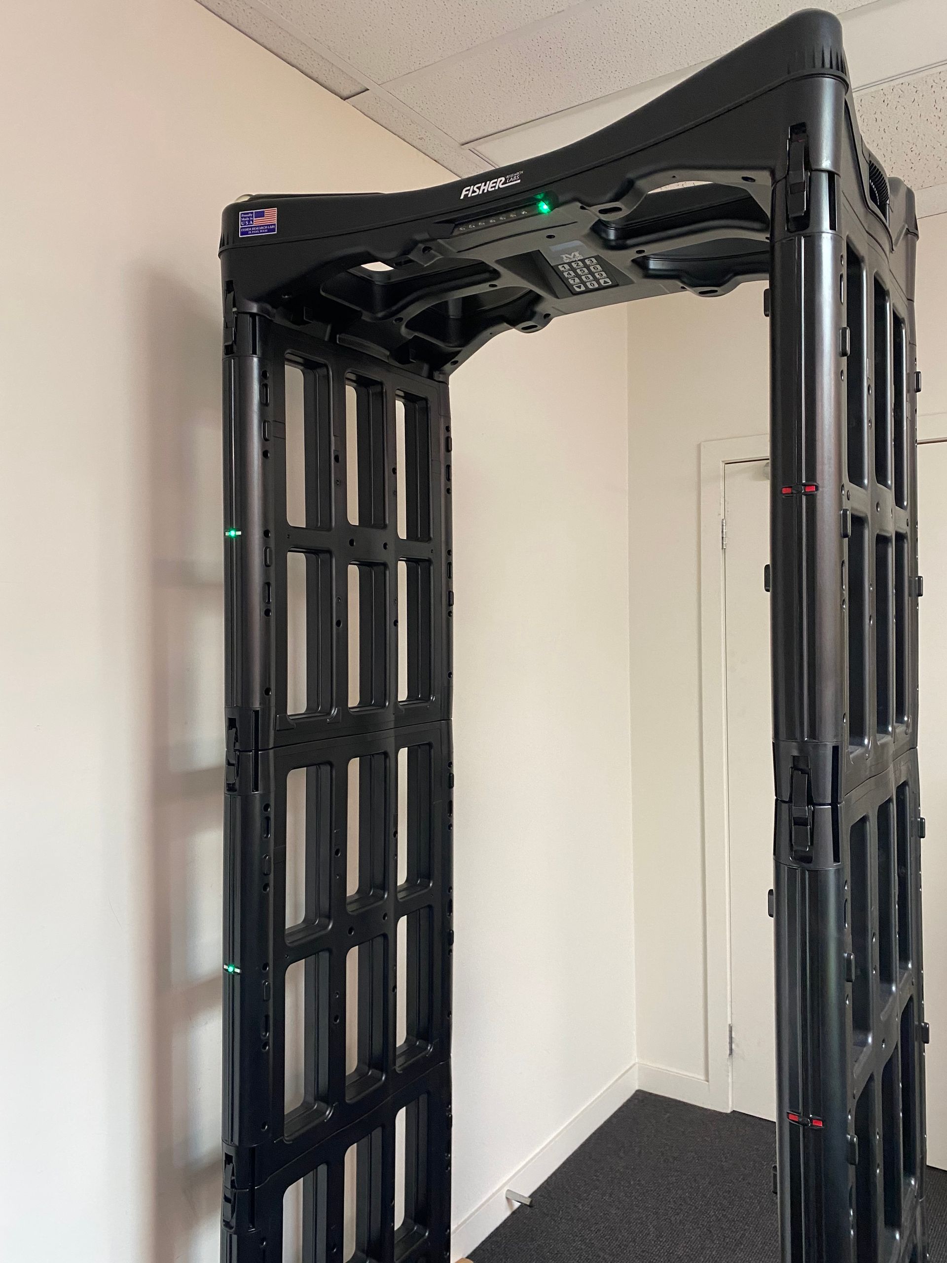 Black security metal detector in an empty corner of a room.