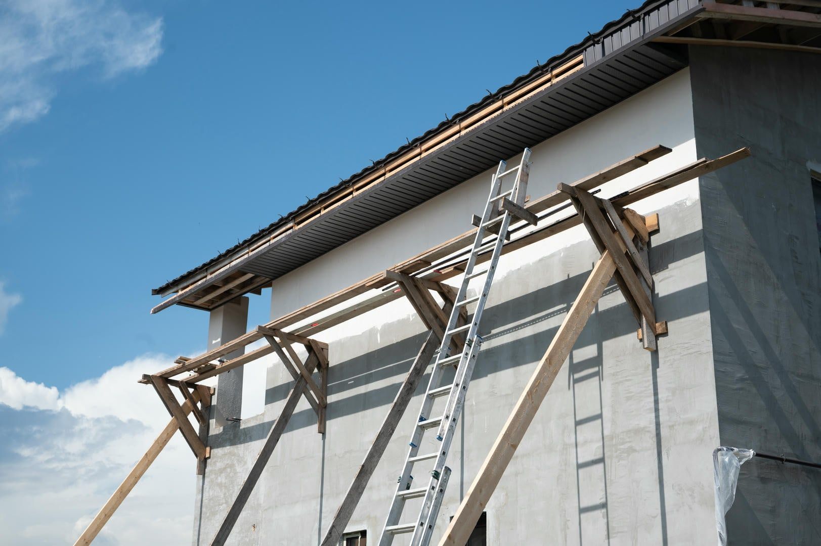 A ladder is attached to the side of a building under construction.