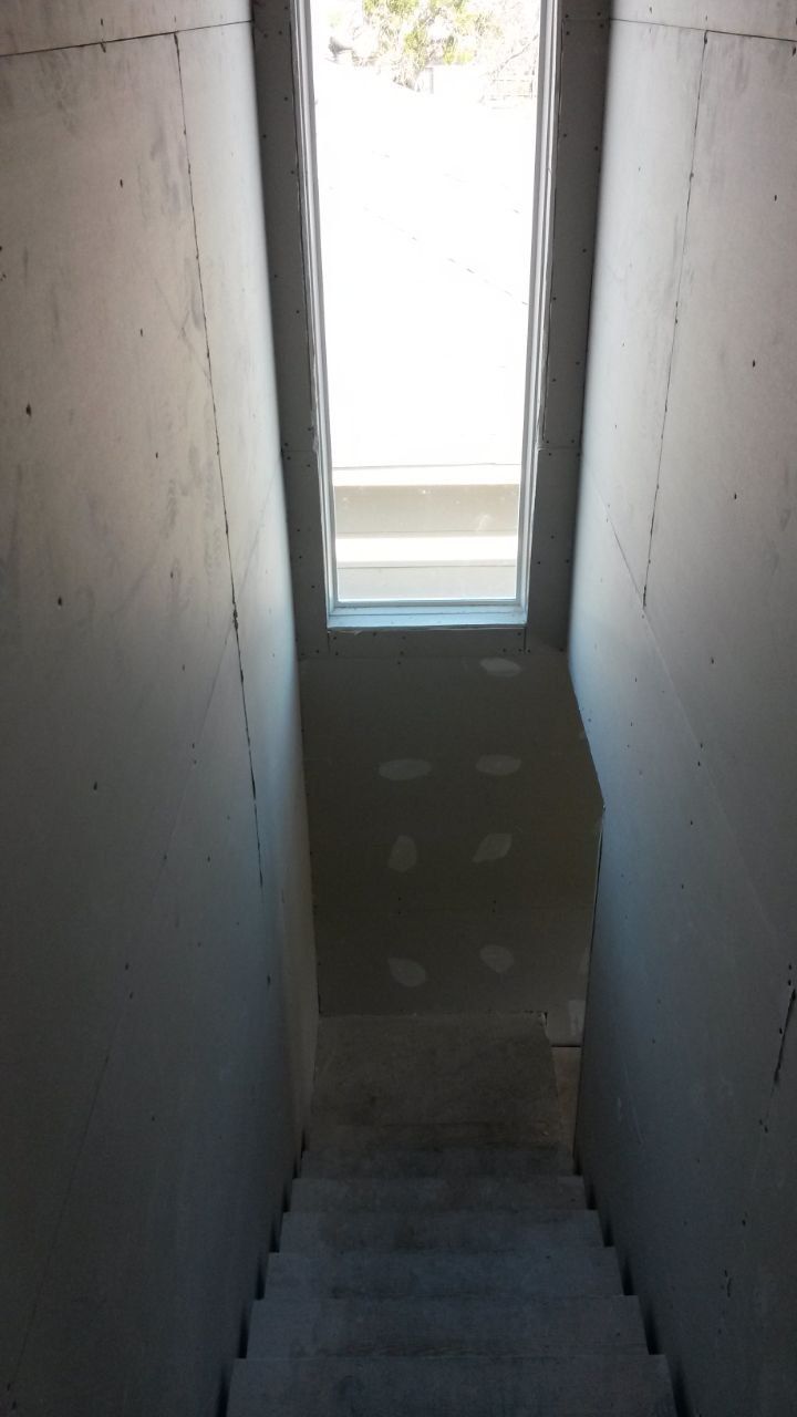 Concrete stairway leading up to a doorway with bright sunlight.