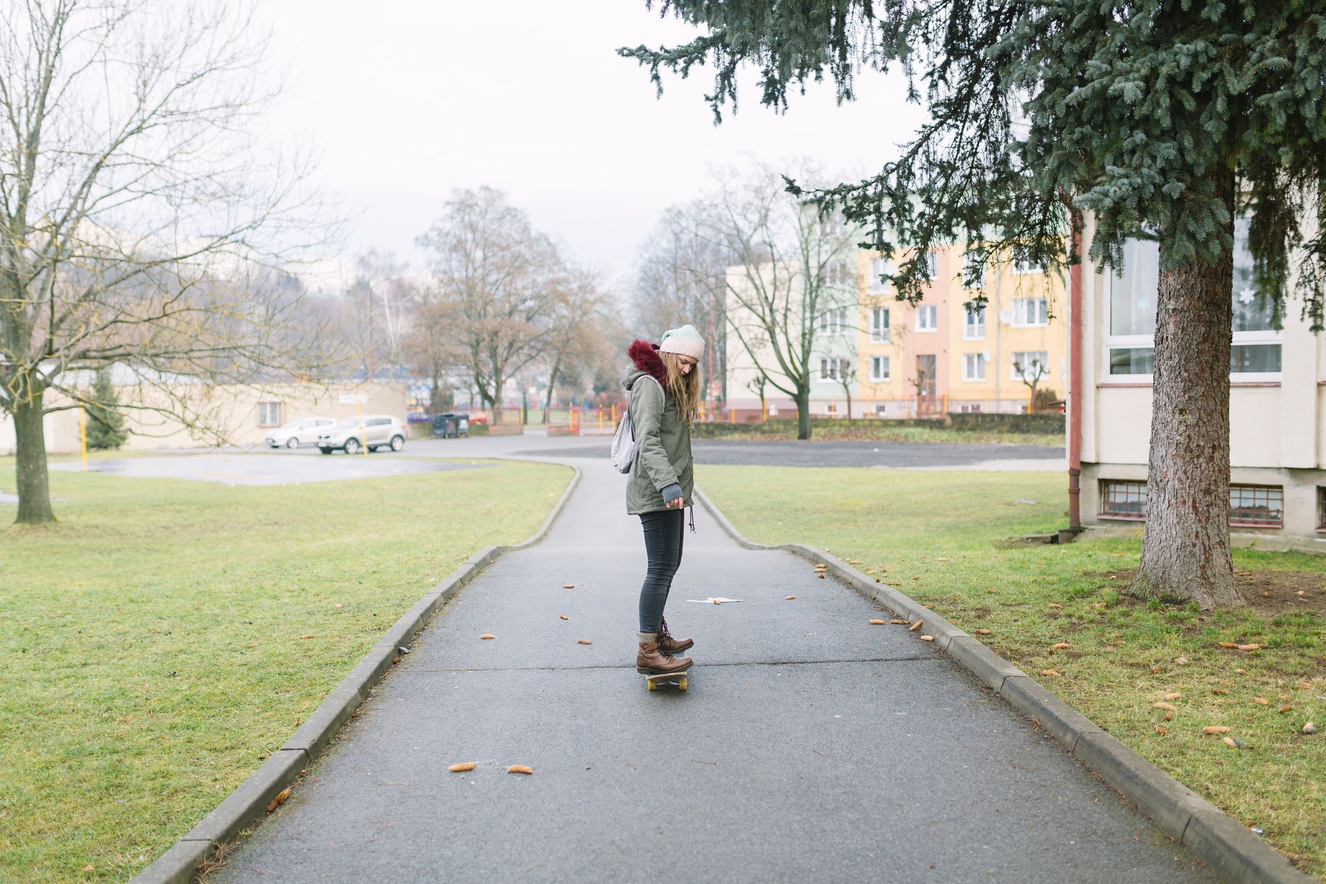 A woman is riding a skateboard down a sidewalk.