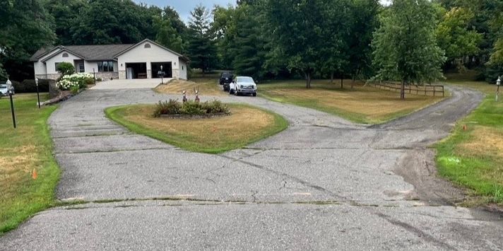 a driveway with a house and trees