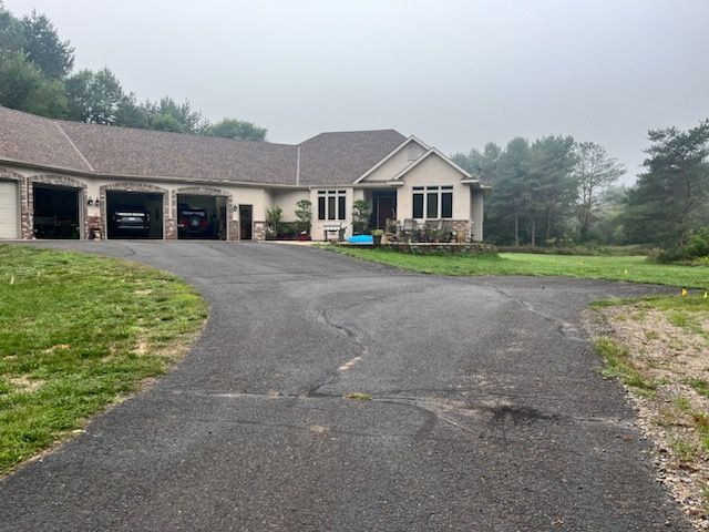 a house with a driveway and trees