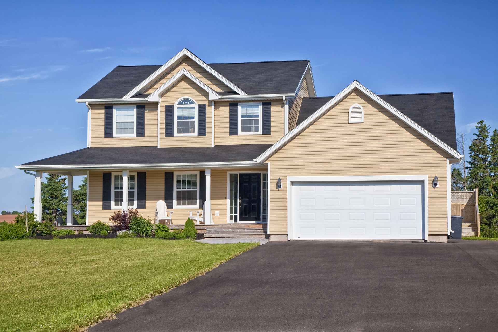 A large house with a white garage door and black shutters