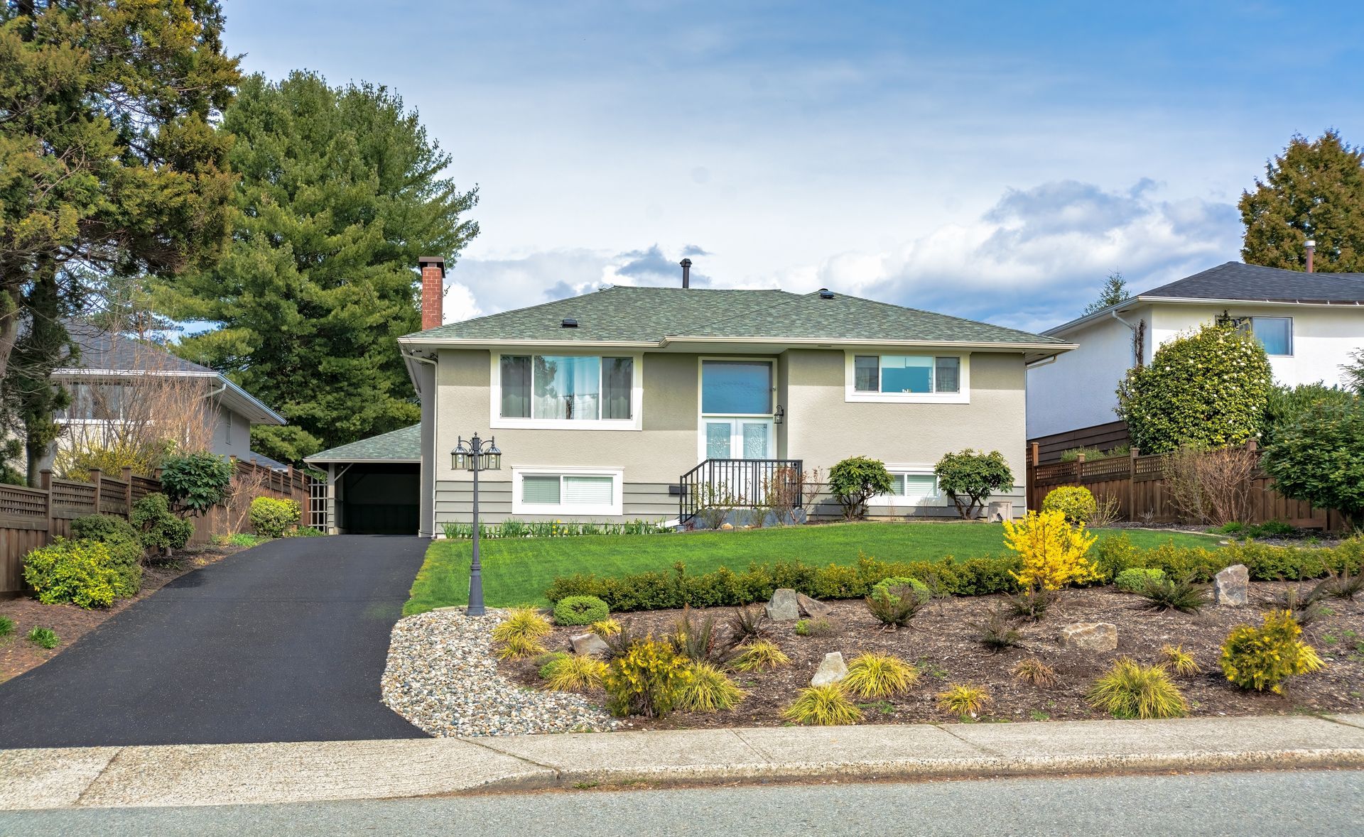 A house with a green roof and a black driveway