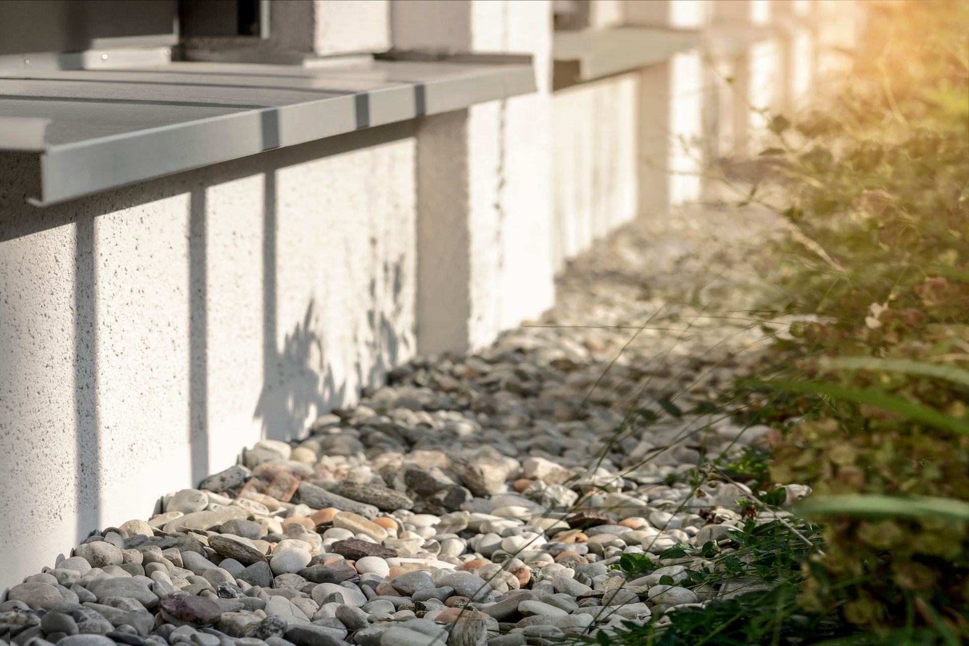 A pile of gravel is sitting in front of a white building.