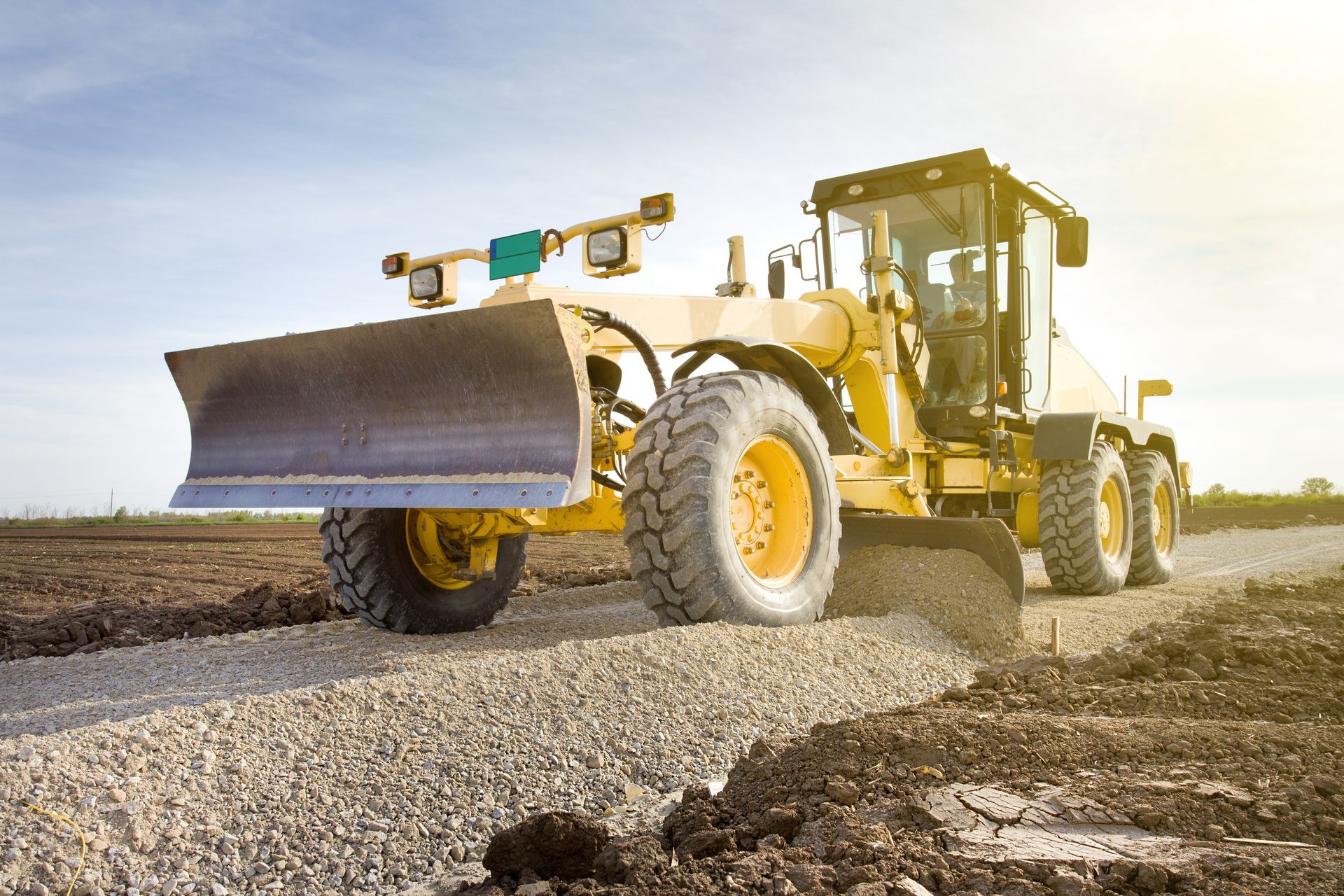 A bulldozer is driving down a dirt road.