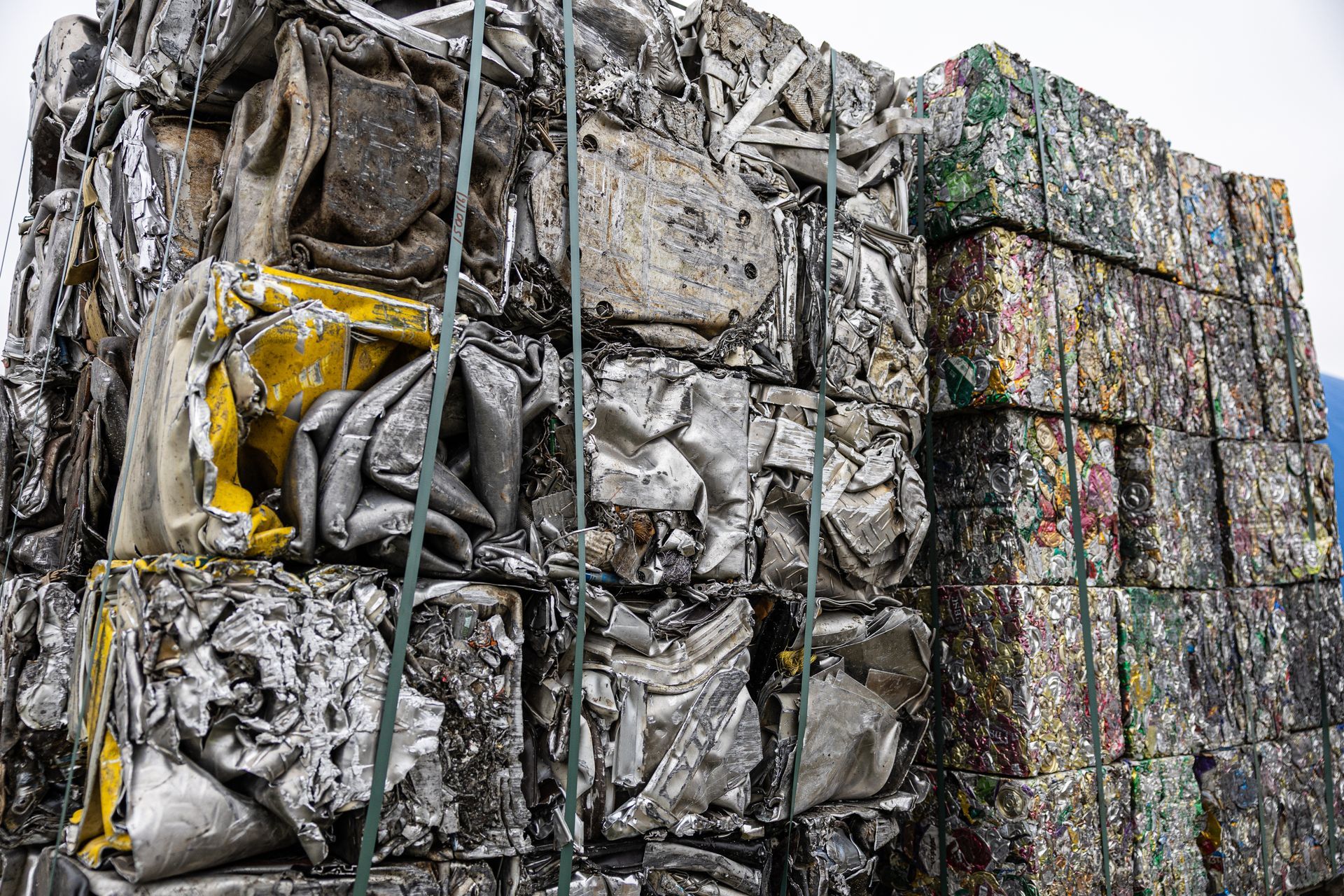Industrial piles of compressed scrap metal and colourful aluminium cans bundled in blocks. Industrial piles of compressed scrap metal and colourful aluminium cans bundled in blocks.