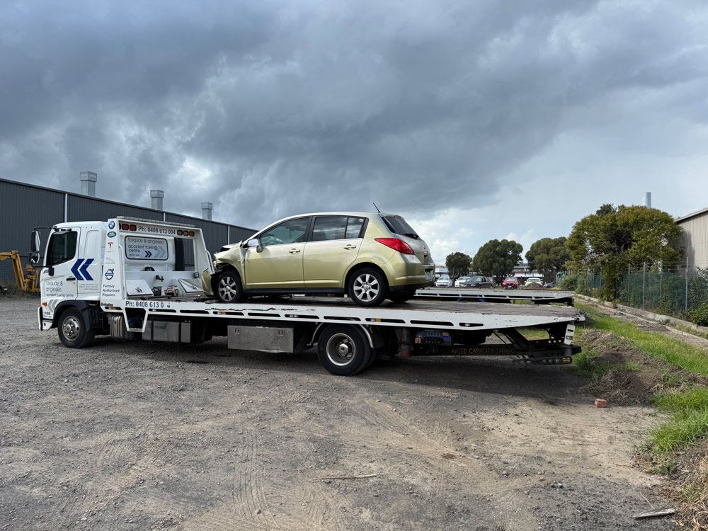 Flatbed Truck Towing a Gold Car