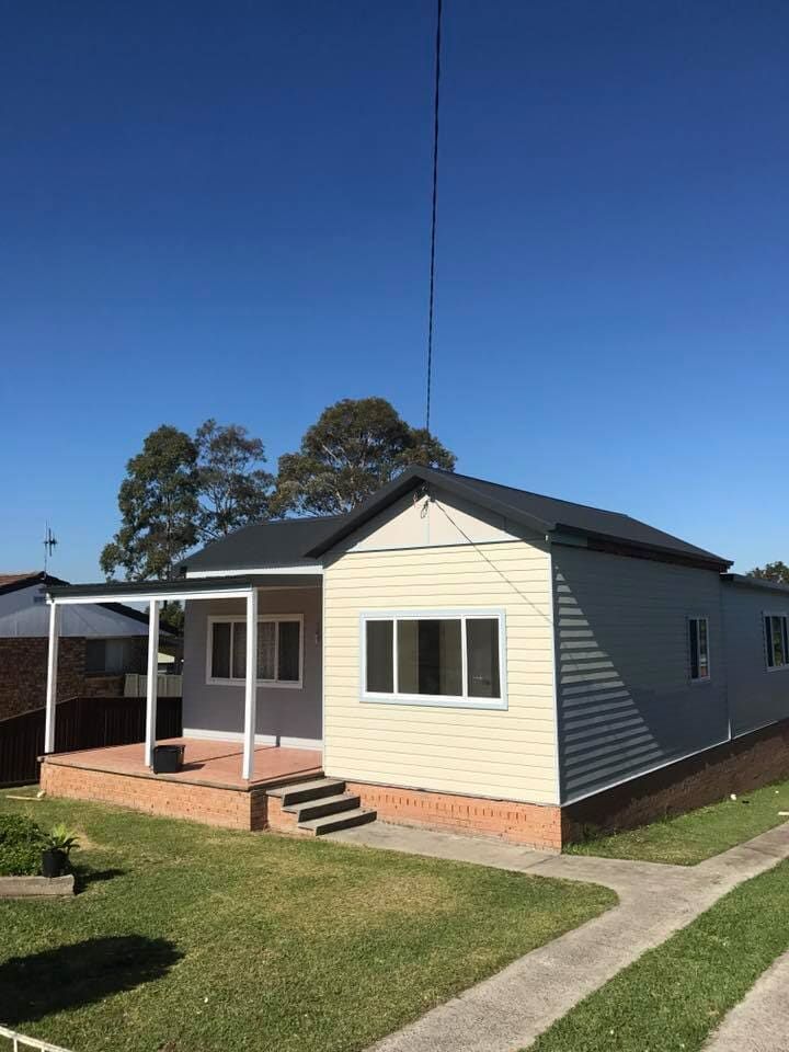 A Small House With a Porch and a Satellite Dish on Top of It — Nathan Parnell Roofing In Vincentia, NSW