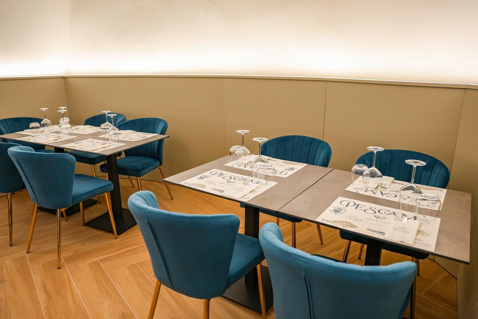 Piatto di frutti di mare con limoni e arance su un tavolo; bottiglie e bicchiere di vino sullo sfondo.