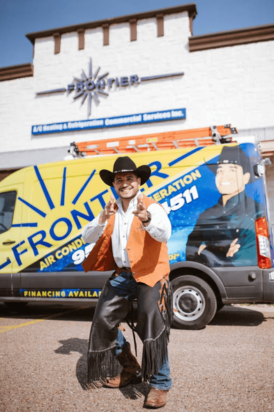 Man in cowboy attire poses by Frontier Air Conditioning van.