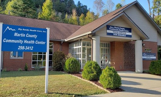 Kent County Community Health Center building with blue sign and brick entrance on a sunny day